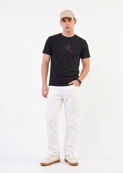 Man wearing a black t-shirt with a logo, white pants, and a beige cap on a white background