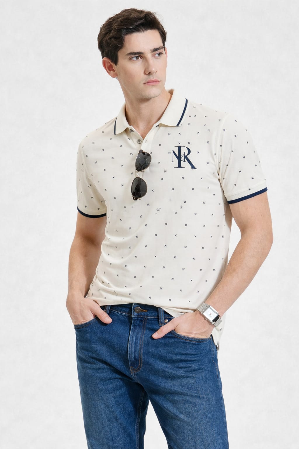 Man wearing a patterned polo shirt with sunglasses on a white background