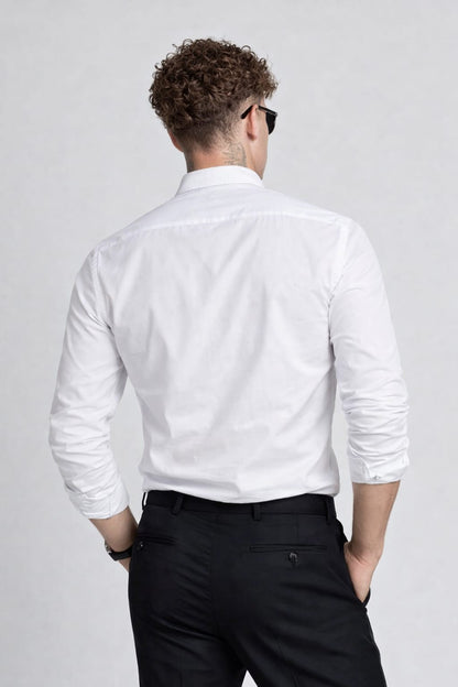 Man wearing a white dress shirt and black pants on a plain background