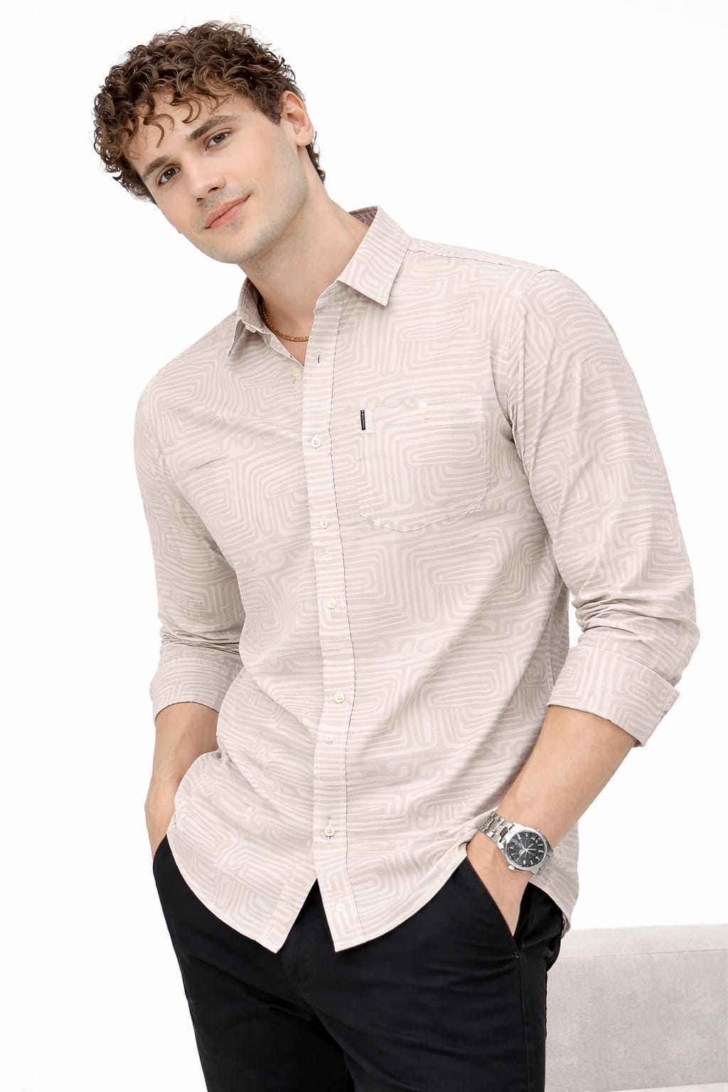 Man wearing a light-colored button-up shirt with a white background