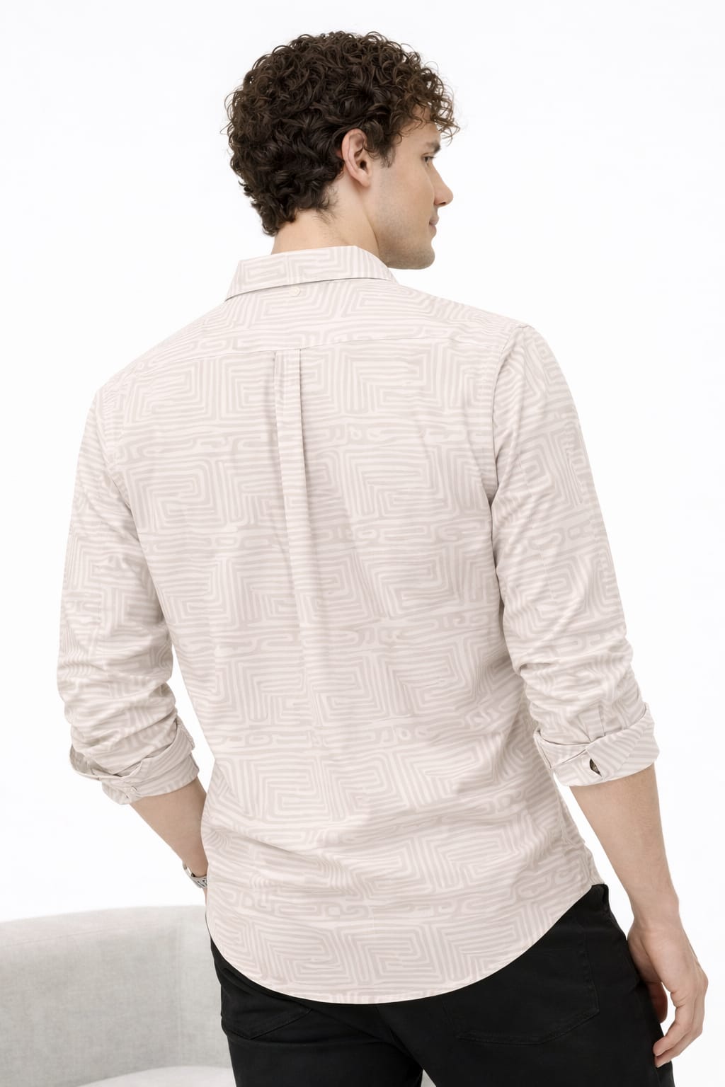 Man wearing a light-colored patterned shirt on a white background