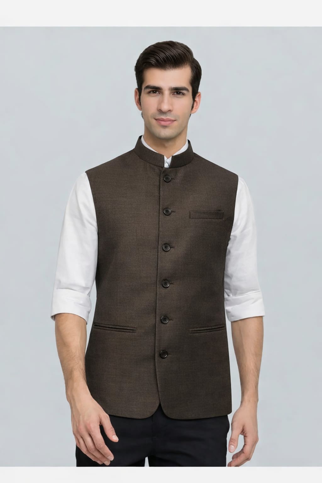 Man wearing a brown vest over a white shirt on a gray background