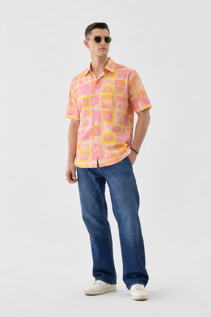 Man wearing a colorful patterned shirt and blue jeans on a white background