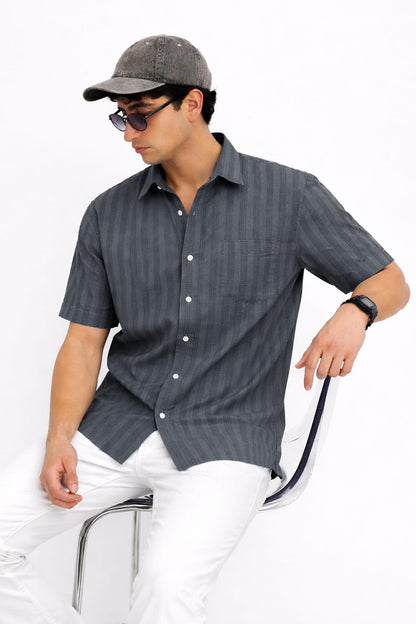 Man wearing a gray striped shirt and cap on a white background