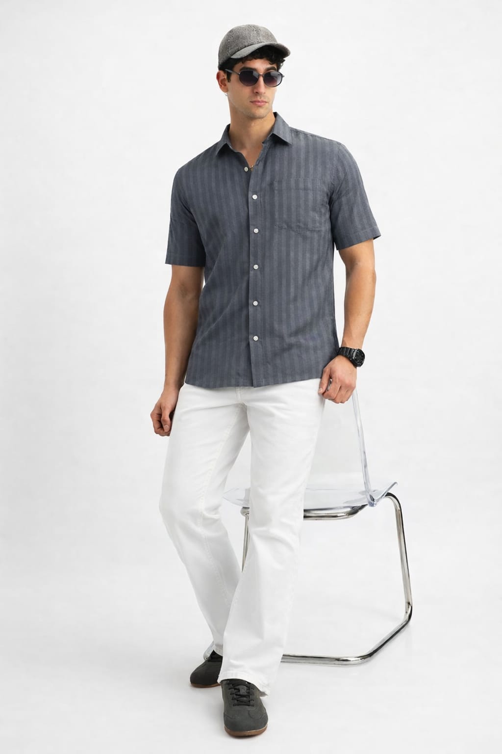 Man wearing a dark striped shirt, white pants, black shoes, and a cap on a white background