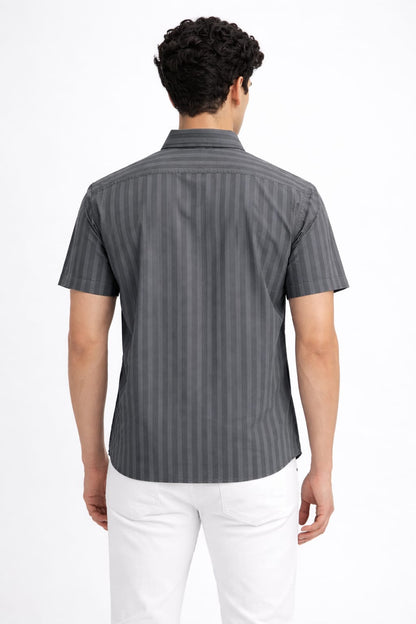 Person wearing a gray striped shirt and white pants on a white background