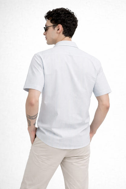Man wearing a white polo shirt and beige pants on a white background