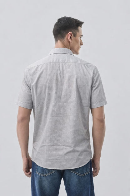 Man wearing a gray short-sleeve shirt and blue jeans on a light gray background