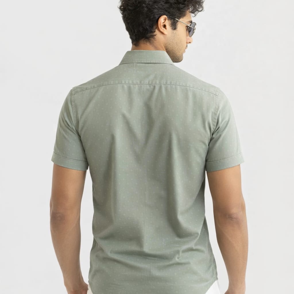 Man wearing a light green shirt on a plain background